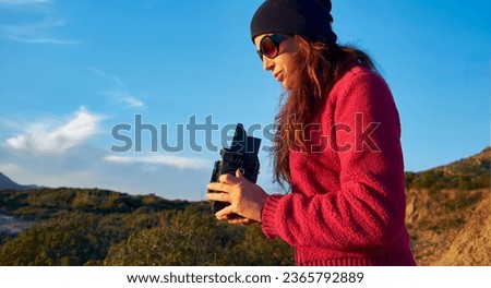 Outdoor activity - woman in mountain landscape, take pictures with camera vintage 6x6. With copy space