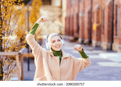 Outdoor Autumn Lifestyle Image Of Middle Age Pretty Hipster Woman 40-45 Year Old Having Fun, Listening Music And Dancing On The Street, City, Cute Beige Trendy Outfit , Fun, Joy, Emotions.