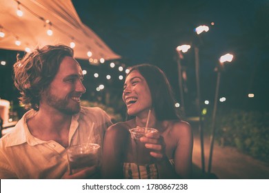 Outdoor bar people drinking cocktails going out at night friends laughing dating couple happy lifestyle.