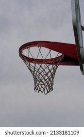 Outdoor basketball hoop under cloudy skies.