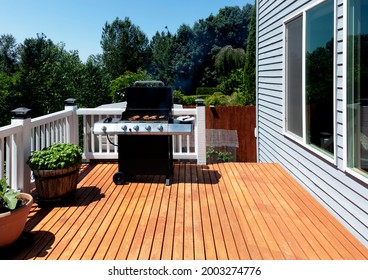 Outdoor BBQ Cooker With Lid Open Displaying Smoke Coming Out While On Home Wooden Deck During Summertime 