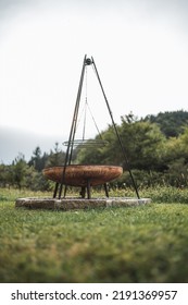 Outdoor Bbq Fire Place Modern Nordic Style In Selective Focus. Bonfire Place With Bbq Grid Or Grill With Blurred Background. Nordic Summer Nature  Outdoor Furniture Blurry In The Background.