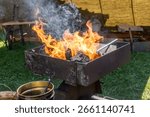 Outdoor Blacksmith Forge with Open Fire and Iron Bars in Rustic Historical Setting