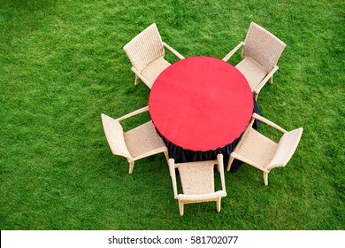 Outdoor Cafe. Top View Of Red Table And Chair On Green Grass.