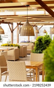 Outdoor Cafe With Wicker Furniture And Lamps. Focus On The Chandelier