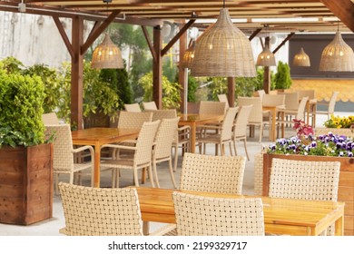 Outdoor Cafe With Wicker Furniture And Lamps. Focus On The Chandelier