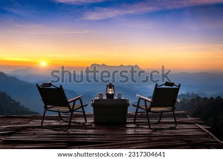 Outdoor camping table set at sunrise. Doi Luang Chiang Dao mountains in Chiang Mai.