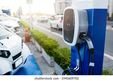 Outdoor Car Park Area With EV Charging Station For Electric Vehicles. Battery Charging For Automobile. Clean Energy For Sustainability. Mega Trend In The Near Future.