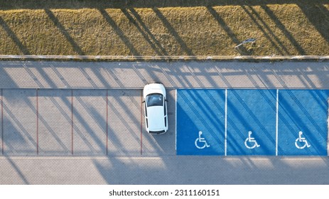 Outdoor car parking with handicapped symbol icon close to railway station.. Parking places reserved for disabled person. Aerial drone view. - Shutterstock ID 2311160151