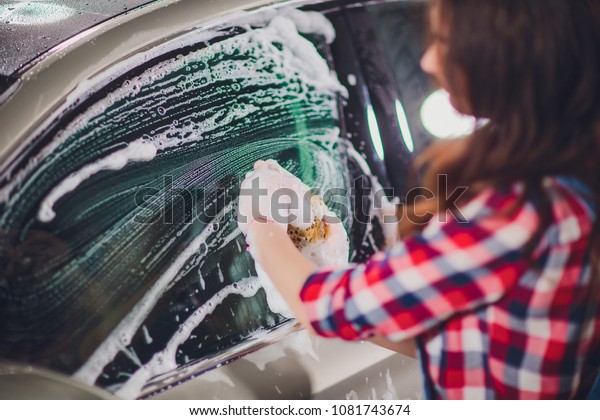 outdoor car wash with yellow sponge. Beautiful girl\
washes car