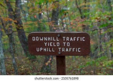 Outdoor Carved Wood Sign That Says DOWNHILL TRAFFIC YIELD TO UPHILL TRAFFIC