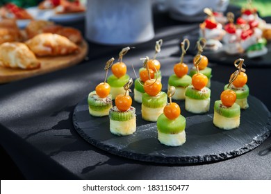 Outdoor catering banquet in summer. Table with canapes and fruits at a summer banquet