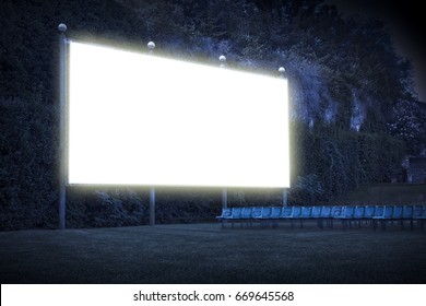 Outdoor Cinema With Chairs And White Projection Screen In Nature - Image With Copy Space
