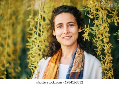 Outdoor Close Up Portrait Of Beautiful Mature Woman With Curly Hair Posing Next Tp Fresh Green Tree