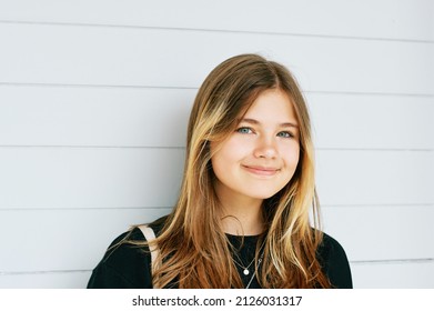 Outdoor close up portrait of pretty young teenage gir with brown hair posing on white background