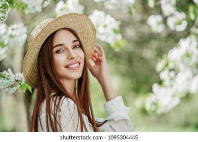 Outdoor Close Up Portrait Of Young Beautiful Happy Smiling Girl With Healthy  Radiant Skin, Long Natural Hair. Model Posing In Flowering Garden. Beauty, Health Concept. Copy, Empty Space For Text