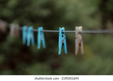 Outdoor Clothes Dryer. Free Space For Ideas. Blue And Wooden Clothespins On A Clothesline. Selective Focus On One Clothespin.