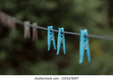 Outdoor Clothes Dryer. Free Space For Ideas. Blue And Wooden Clothespins On A Clothesline. Selective Focus On One Clothespin.