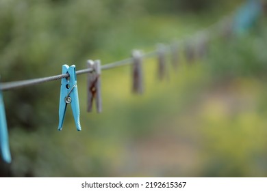 Outdoor Clothes Dryer. Free Space For Ideas. Blue And Wooden Clothespins On A Clothesline. Selective Focus On One Clothespin.