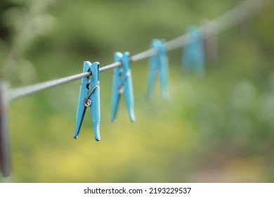 Outdoor Clothes Dryer. Free Space For Ideas. Blue And Wooden Clothespins On A Clothesline. Selective Focus On One Clothespin.