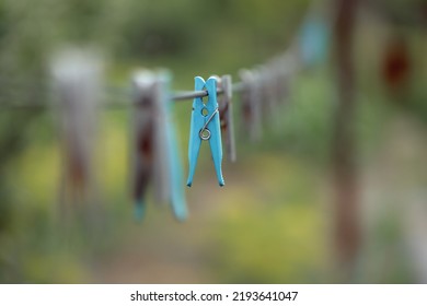 Outdoor Clothes Dryer. Free Space For Ideas. Blue And Wooden Clothespins On A Clothesline. Selective Focus On One Clothespin.