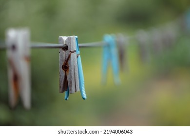 Outdoor Clothes Dryer. Free Space For Ideas. Blue And Wooden Clothespins On A Clothesline. Selective Focus On One Clothespin.