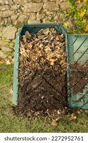 Outdoor compost bin was opened to extract mature compost formed in the down part.The compost bin is placed in a home garden to recycle organic waste produced in home. Concept of sustainability