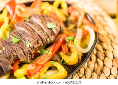 Outdoor Cooking. Steak Fajitas With Bell Peppers And Yellow Onion On A Cast Iron Fajita Skillet.