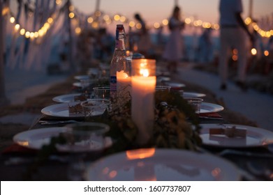 Outdoor Dinner Party Place Settings With Strings Of Lights And Candles