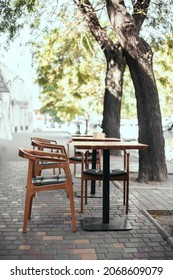 Outdoor Empty Street Restaurant With Wood Stile Chairs In Summer On City Street. Coronavirus Crisis