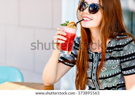 Outdoor fashion beauty portrait of glamour elegant lady, amazing long hairs, luxury vintage dress and cat eye sunglasses, drinking tasty cold cocktails, city cafe terrace, travel, joy, relax.