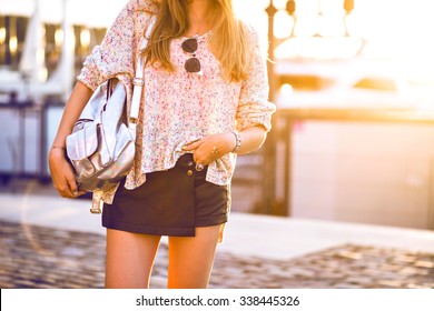 Outdoor Fashion Image Of Woman Wearing Mini Leather Skirt, Cozy Relaxed Light Sweater , Silver Backpack, Vintage Sunglasses, Fashion Close Up Details, Sunshine Autumn Colors.