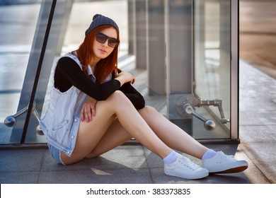 Outdoor fashion lifestyle portrait of pretty young girl, wearing in hipster swag grunge style urban background. Tomboy city concept