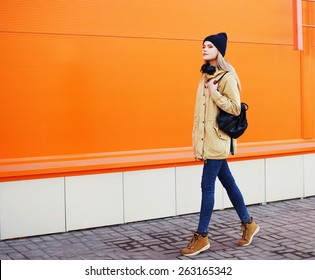 Outdoor Fashion Photo Of Stylish Hipster Cool Girl Walking In The City Against A Colorful Urban Wall