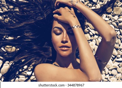 Outdoor fashion portrait of sexy lady lying at beach