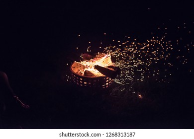 An Outdoor Fire With Embers Floating In The Air