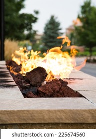 An Outdoor Fireplace Burning At Dusk