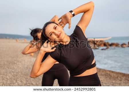 Outdoor fitness. Portrait of smiling beautiful young Caucasian woman training on wild beach. Yoga class. Concept of sports lifestyle.