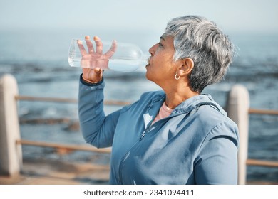 Outdoor, fitness or senior woman drinking water for hydration, wellness and thirsty on beach run, training or exercise. Bottle, runner or elderly person refresh with cold liquid on retirement workout - Powered by Shutterstock