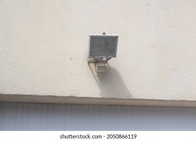 Outdoor Floodlight With A Motion Detector On The Wall Of A Garage