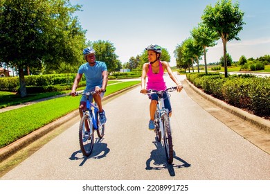 Outdoor Fun And Fitness For Happy Young African American Couple Enjoying Leisurely Cycle Ride Wearing Bike Helmets