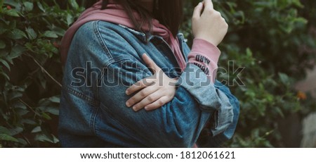 Similar – Frau mit Jeansjacke, blauer Bluse und silberner Armbanduhr.