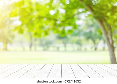 Outdoor Green Nature Background, Empty White Wood Table, Perspective Wooden Terrace Over Blur Tree Park With Bokeh I Spring, Summer For Food And Product Display Montage Template, Mock Up, Banner