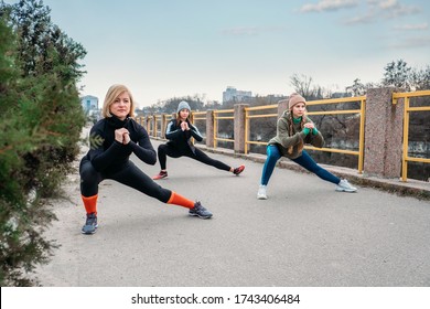 Outdoor Gym Fitness Classes, Outside Workout. Fitness In The Fresh Air. Safer Outside. Group Fitness Classes, HIIT Training, Run Clubs, Strength Circuits. Three Women Are Training In City Park.