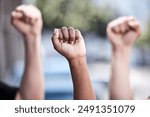 Outdoor, hands and fist in protest for freedom, human rights and equality with community campaign. Diversity, people or protesters with teamwork in strike, raise awareness and advocacy for change