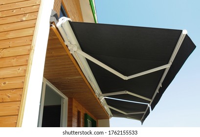 Outdoor high quality automatic sliding canopy retractable roof system, patio awning for sunshade of a modern wooden house.  