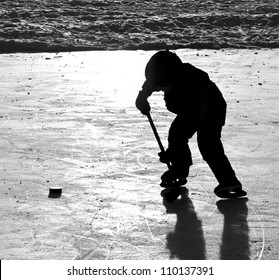 Outdoor Ice Hockey, Silhouette Of Boy Skating With Puck And Stick