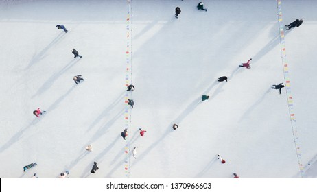 Outdoor Ice Skating Rink With People Riding On A Winter Day. Aerial View From The Drone.