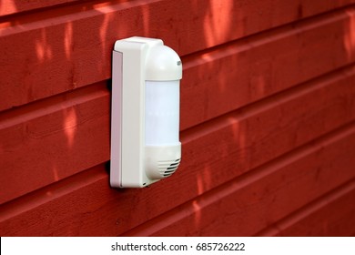 Outdoor infrared  motion detector on the wooden wall - Shutterstock ID 685726222
