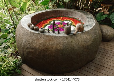 Outdoor Jungle View Stone Round Bath Tub With Flower Petals. Luxury Stone Bath Tub With Tropical Flowers For Beauty Spa Treatment, Relaxation In Hotel. Tropical Escape, Bali Style Spa